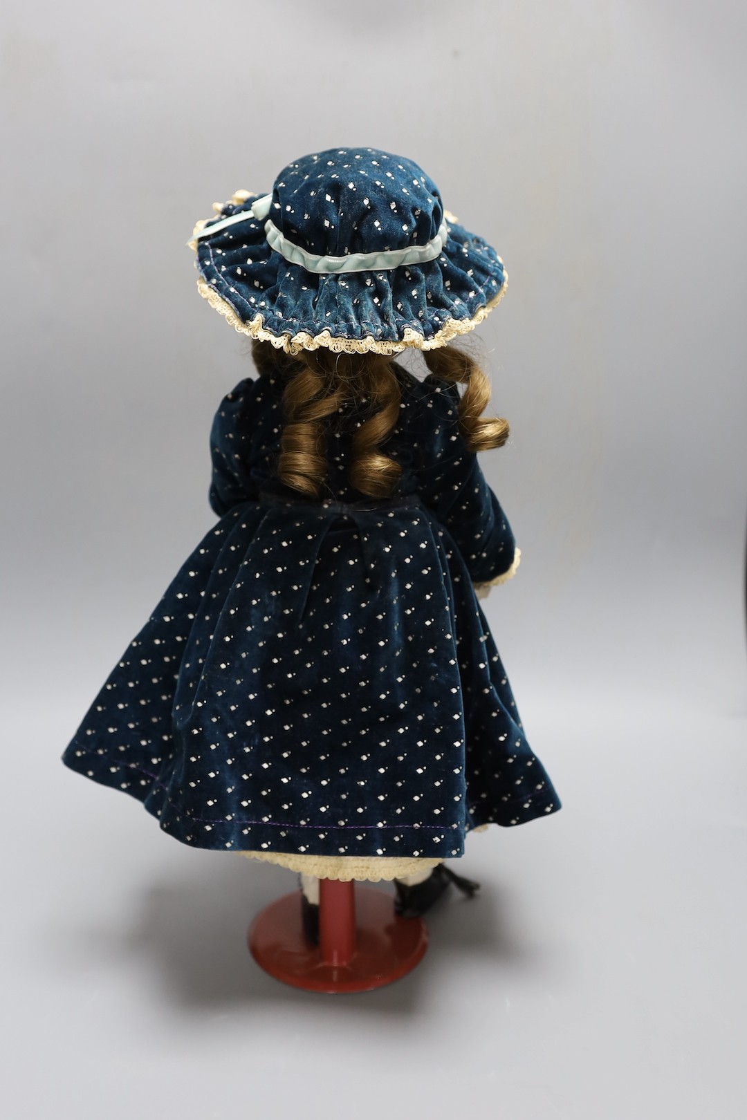 A Simon & Halbig doll, cream satin dress and blue velvet coat, open mouth, 44.5 cms high.